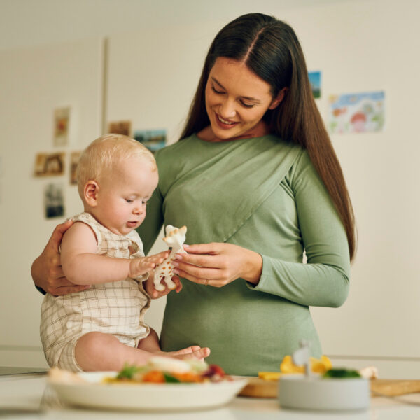 Majka s bebom u kuhinji igra se s popularnom žirafom - bezbrižni trenuci bez brige o alergijama