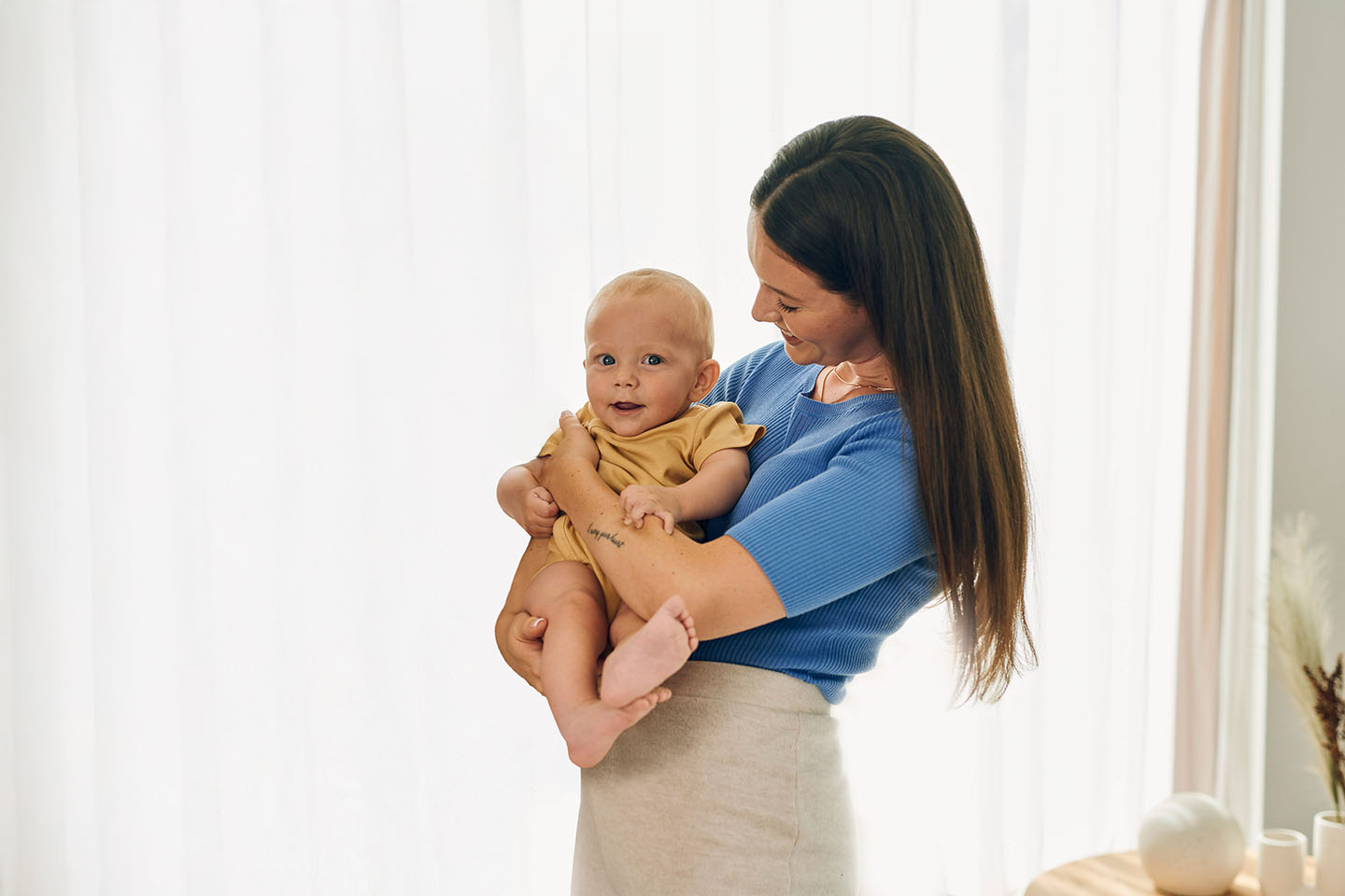 Majka drži svoju bebu u naručju i s ljubavlju je gleda.