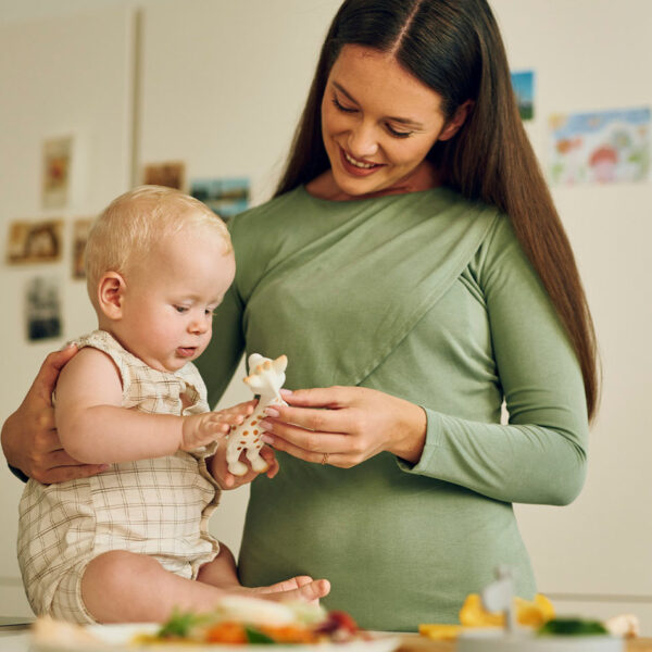 Majka s bebom u kuhinji igra se s popularnom žirafom - bezbrižni trenuci bez brige o alergijama