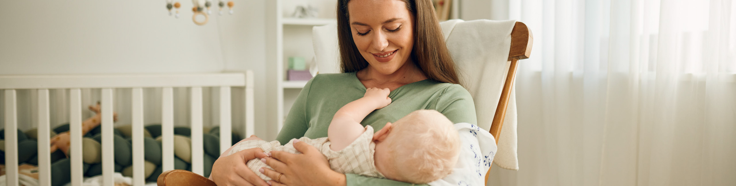 Majka u ljuljački s bebom u naručju.