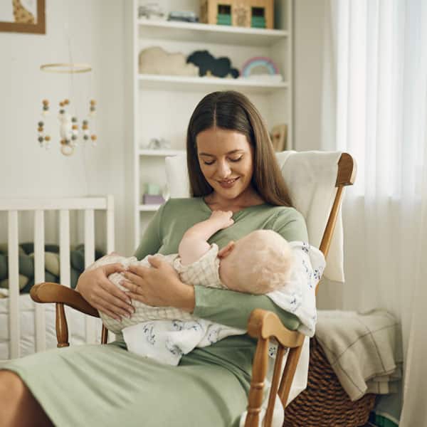 Majka u ljuljački s bebom u naručju.