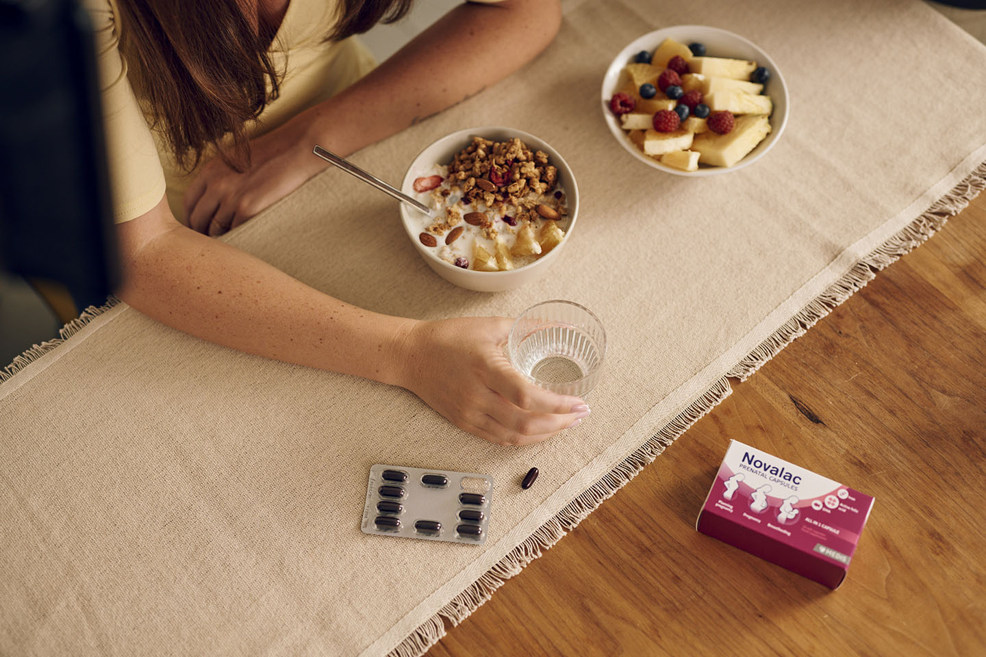 Žene razbijaju doručak s pahuljicom i čašom vode u prenatalnim kapsulama Novalac.