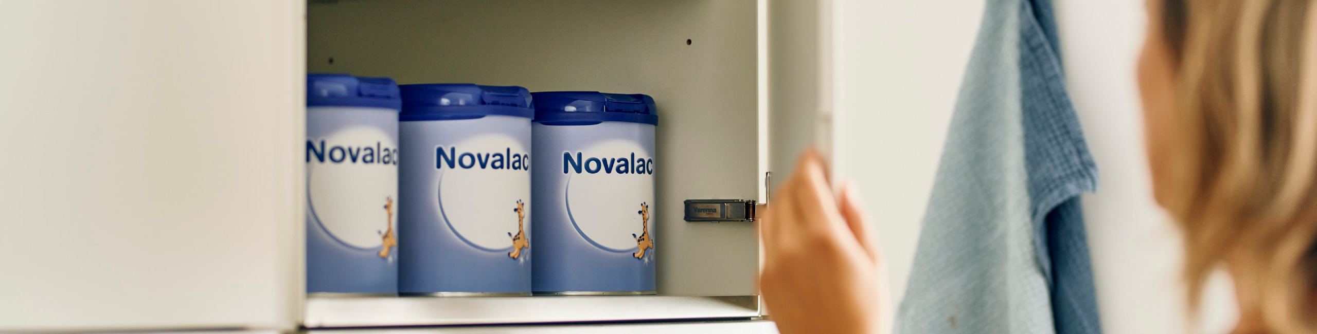 Mama poseže za Novalac formulama naslaganim na kuhinjskoj polici