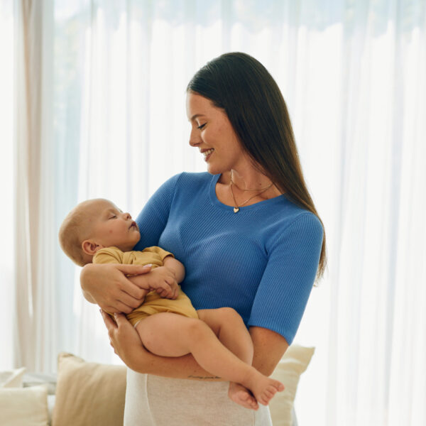 Majka drži novorođenče u svijetloj sobi